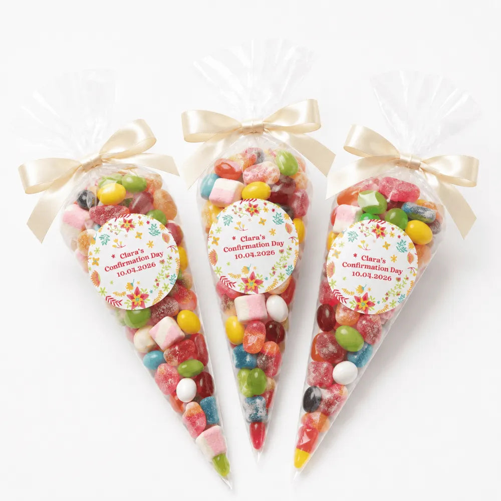 Three clear plastic confirmation sweet cones filled with colorful gummies tied with gold ribbons and floral labels