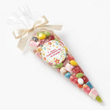 A clear cellophane sweet cone filled with colorful jelly beans and marshmallows tied with cream satin ribbon for confirmation sweet cones