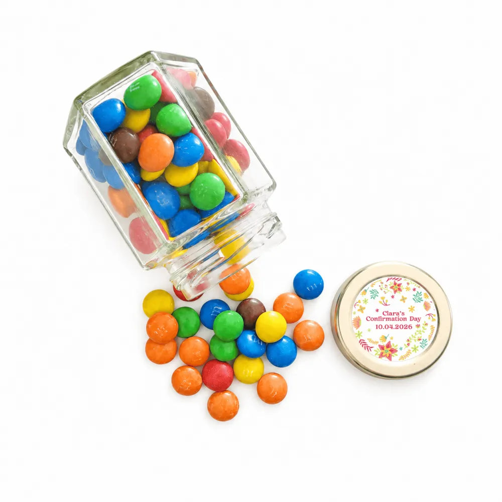 Clear glass hex jar favour with 48mm pale gold twist lid filled with colorful m&m’s and personalised sticker printed