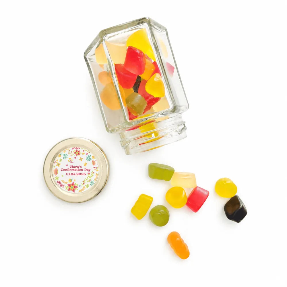 Clear glass hex jar with 48mm pale gold twist lid and personalised sticker filled with colorful gummies wildflower blessing