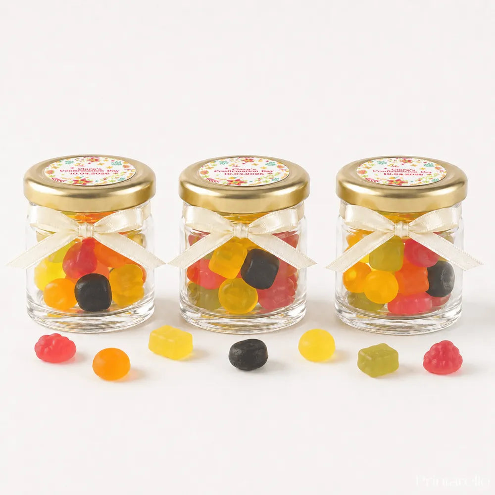 Three clear glass jars with 43mm pale gold lids and cream ribbons filled with colorful gummies and personalised stickers